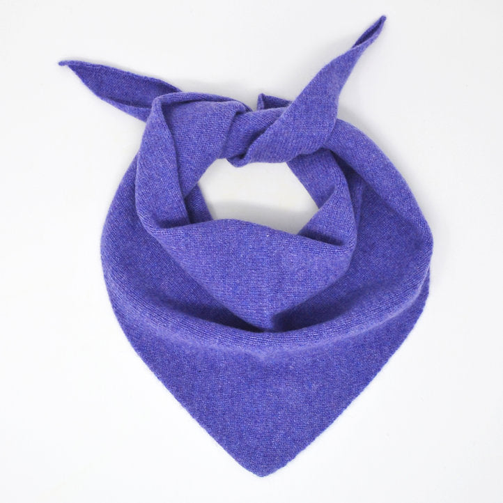 A Scarlet Knitwear brand lambswool triangle scarf in dark heather (a bright purple), arranged as it would be worn.