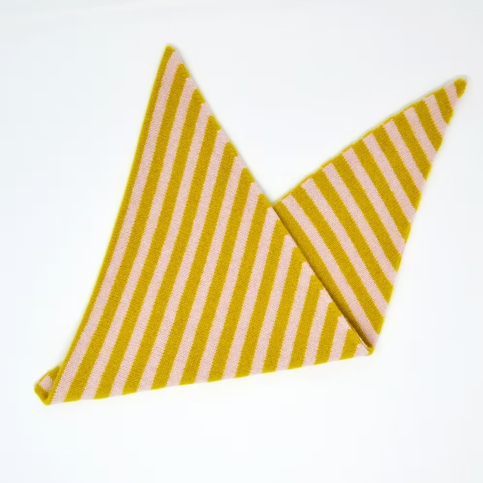 A folded Scarlet Knitwear brand lambswool triangle scarf with a light pink and mustard stripe design.