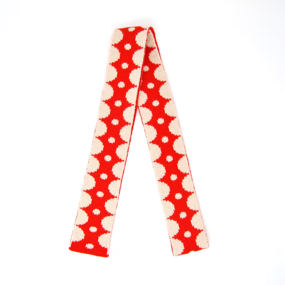 A Scarlet Knitwear brand skinny 100% lambswool scarf with a red and cream geometric design.