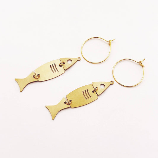 A pair of gold-tone fish-shaped dangle earrings with matching hoop backings, displayed on a clean white background.