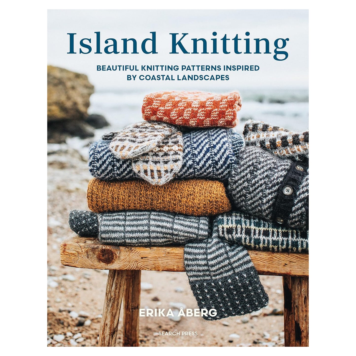 The book cover of Island Knitting, by knitwear designer Erika Åberg. It shows a stack of colourful patterned knitwear on a wooden bench on the beach. The subtitle is 'beautiful knitting patterns inspired by coastal landscapes'.