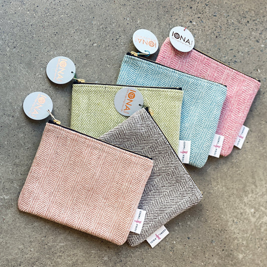 Five large rectangular coin purses made from single origin Iona Tweed in vibrant colours and traditional patterns with brass zips, certification side labels and Iona Craft Shop tags.