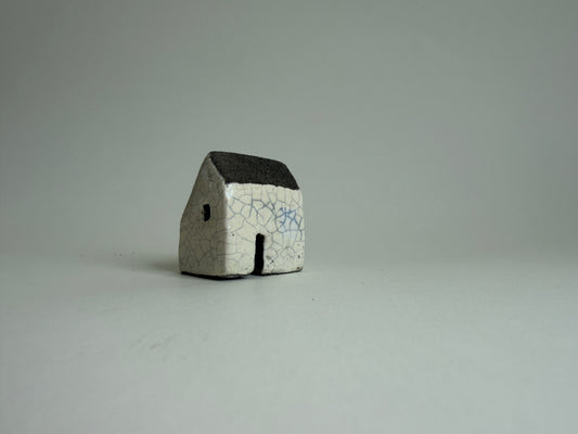 small cream ceramic house on a pale grey background
