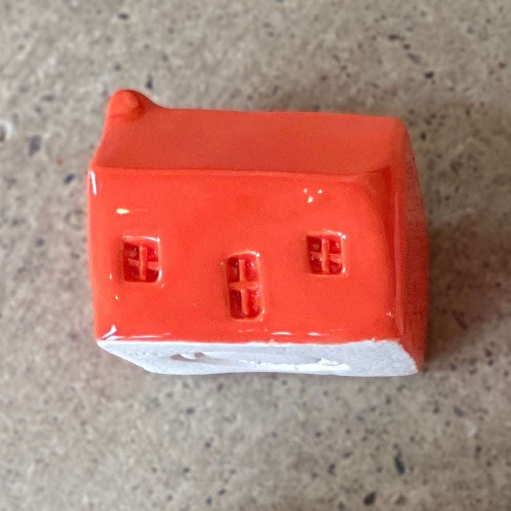 A handmade ceramic bothy with a bright red glaze.