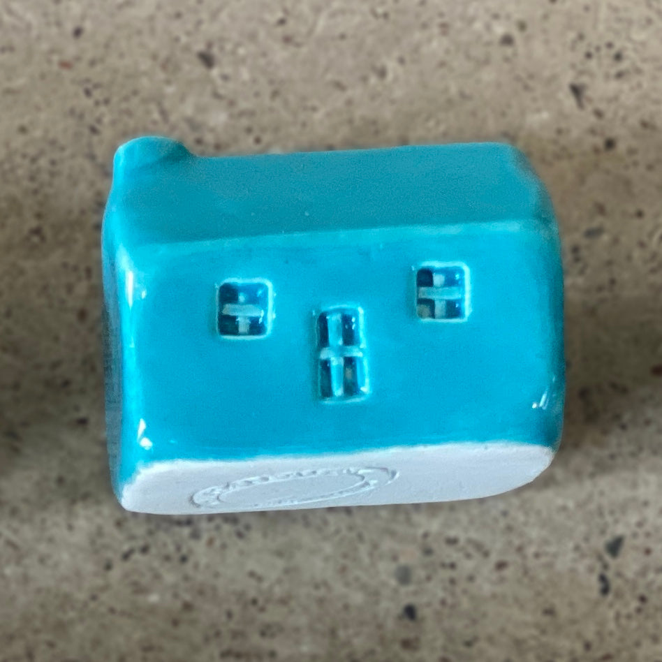A handmade ceramic bothy with a bright turquoise glaze.
