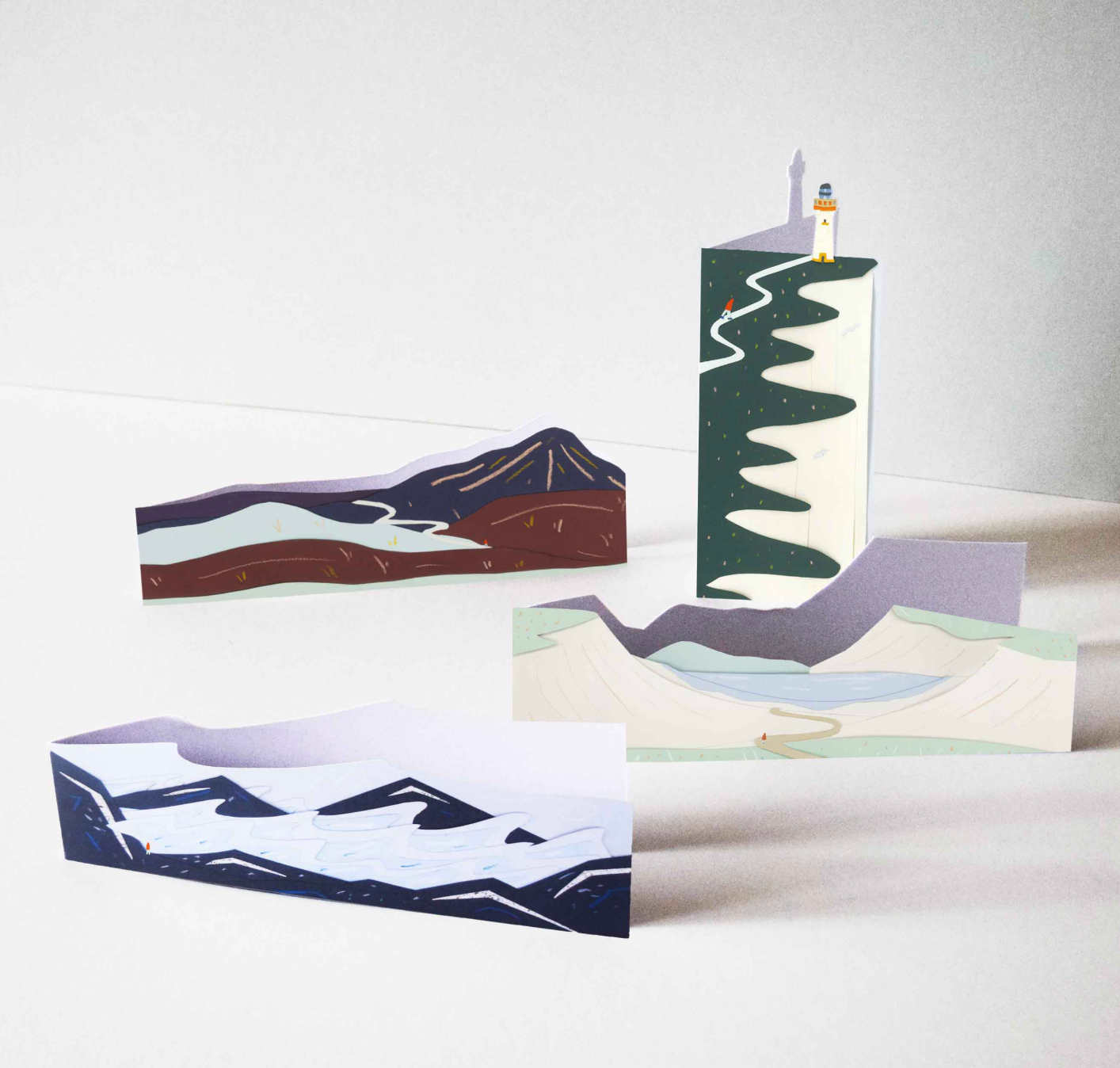 A set of 4 cards with digitally scanned prints of original, hand-cut illustrations of landscapes, cut to shape.