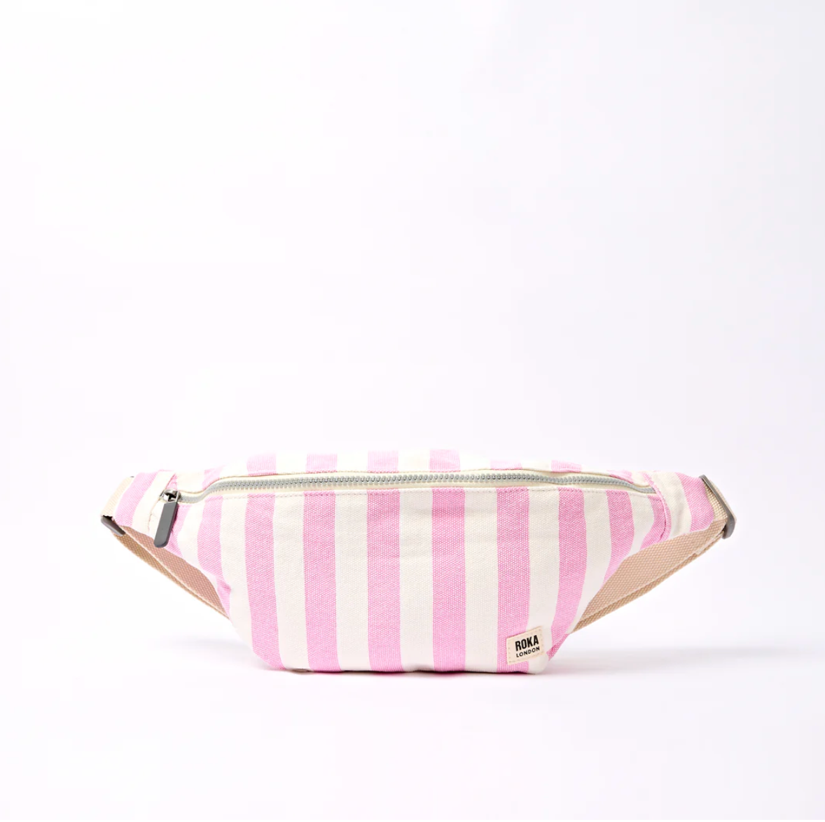 A pink and white vertically striped canvas sling bag with a beige strap and a small ROKA brand tag on the front, set against a plain white background.

